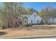Charming single Gathering home with a stone-accented facade, mature trees, and a well-manicured lawn at 3619 Elinburg Ne Ct, Buford, GA 30519