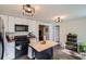 Practical kitchen with an island, modern lighting and black appliances at 3619 Elinburg Ne Ct, Buford, GA 30519