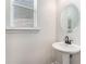 Bathroom features a pedestal sink, oval mirror, and window providing natural light at 847 Venture Sw Way, Atlanta, GA 30331
