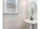 Neat half bathroom featuring a pedestal sink, modern fixtures, and window that allows natural light in at 847 Venture Sw Way, Atlanta, GA 30331