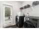 Functional laundry room with modern washer and dryer, storage shelves, and a convenient exterior door at 847 Venture Sw Way, Atlanta, GA 30331
