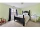 Bright bedroom features green walls, a window with dark curtains, and a black wooden bed frame at 2205 Parliament Dr, Lawrenceville, GA 30043