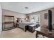 Comfortable bedroom offers natural light, neutral tones, and a classic wood bed frame and writing desk at 2205 Parliament Dr, Lawrenceville, GA 30043