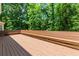 A close up of the deck with built in bench seating and a view of the trees at 2205 Parliament Dr, Lawrenceville, GA 30043