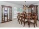 An elegant dining room with wood table, upholstered chairs, and two display cabinets at 2205 Parliament Dr, Lawrenceville, GA 30043