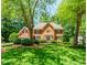 Charming two-story red brick home with manicured lawn and mature trees at 2205 Parliament Dr, Lawrenceville, GA 30043