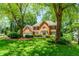 Traditional brick home featuring an attached garage and lush landscaped front yard at 2205 Parliament Dr, Lawrenceville, GA 30043