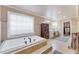 Bright main bathroom with a large tub and window at 2205 Parliament Dr, Lawrenceville, GA 30043