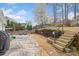 Fenced backyard with a concrete patio, outdoor dining set, wood steps, and manicured landscaping at 2692 Glenrose Hl, Atlanta, GA 30341