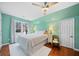 Cozy bedroom featuring a large window, hardwood floors, and soft white bedding with decorative lamps at 2692 Glenrose Hl, Atlanta, GA 30341