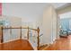 Upstairs hallway with hardwood floors, white railings, and trim leading to a room with comfortable blue furniture at 2692 Glenrose Hl, Atlanta, GA 30341