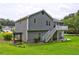 Home exterior featuring a cozy backyard with a wooden pergola, deck with stairs, and ample green space at 4090 Mark Todd Ct, Hoschton, GA 30548