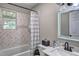 Bathroom with white tile tub, updated vanity and stylish mirror at 4090 Mark Todd Ct, Hoschton, GA 30548