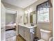 Well-lit bathroom with double vanity sinks and access to an adjacent bedroom at 4090 Mark Todd Ct, Hoschton, GA 30548