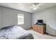 Cozy bedroom with natural light, ceiling fan, carpet flooring, and simple decor at 4090 Mark Todd Ct, Hoschton, GA 30548
