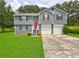 Inviting two-story home with a bright red front door, attached two-car garage, and lush green lawn at 4090 Mark Todd Ct, Hoschton, GA 30548