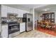 Well-equipped kitchen with stainless steel appliances and white cabinetry, adjacent to the dining area at 4090 Mark Todd Ct, Hoschton, GA 30548