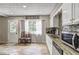 Well-lit kitchen with stainless steel appliances, white cabinets, and a view to the outdoors at 4090 Mark Todd Ct, Hoschton, GA 30548
