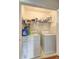 Functional laundry room with appliances, shelf, and white walls at 4090 Mark Todd Ct, Hoschton, GA 30548