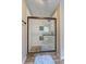 Modern glass shower with decorative tiles, stone floor, and elegant fixtures at 4090 Mark Todd Ct, Hoschton, GA 30548