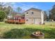 Spacious backyard featuring deck, grassy area, brick fire pit, and neutral-toned siding at 1736 Inas Way, Tucker, GA 30084