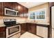 Updated kitchen features stainless steel appliances, granite countertops, and dark wood cabinets at 1736 Inas Way, Tucker, GA 30084