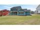 Wide backyard view of the home, featuring a covered patio, large windows, and spacious lawn at 4041 Andover Cir, Mcdonough, GA 30252
