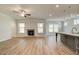 Open-concept living room with fireplace, wood floors, and seamless kitchen integration at 4041 Andover Cir, Mcdonough, GA 30252