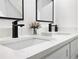 Bright bathroom features black fixtures, dual sinks, quartz countertops and vanity at 580 Hutchens Se Rd, Atlanta, GA 30354