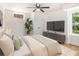 Light-filled bedroom featuring a large window, TV, ceiling fan, and comfortable king-sized bed at 580 Hutchens Se Rd, Atlanta, GA 30354