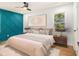 Bedroom features modern ceiling fan, hardwood floors, decorative blue accent wall, and natural light at 580 Hutchens Se Rd, Atlanta, GA 30354
