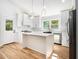 Well-lit kitchen featuring an island with quartz countertops, stainless steel appliances, and bright white cabinetry at 580 Hutchens Se Rd, Atlanta, GA 30354