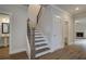 Hallway featuring hardwood floors, a staircase with iron railings, and access to a powder room at 4045 Andover Cir, Mcdonough, GA 30252