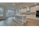 Modern kitchen with white cabinets, large island, stainless steel appliances, and hardwood floors at 4045 Andover Cir, Mcdonough, GA 30252