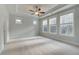 Sun-filled main bedroom with plush carpet, a tray ceiling, and large windows offering a comfortable retreat at 4045 Andover Cir, Mcdonough, GA 30252