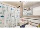 Cozy bathroom featuring a charming shower curtain, vanity, and well-lit mirror at 410 Killian Hill Sw Rd, Lilburn, GA 30047