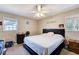Bright, neutral bedroom with a large bed, ceiling fan, and natural light from two windows at 410 Killian Hill Sw Rd, Lilburn, GA 30047