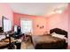 Bright bedroom with pink walls, a comfortable bed, and a desk, offering a cozy retreat at 410 Killian Hill Sw Rd, Lilburn, GA 30047