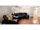 Spacious living room with hardwood floors, and a large black leather sectional sofa at 410 Killian Hill Sw Rd, Lilburn, GA 30047