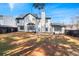 Spacious backyard featuring a well-maintained lawn, fence and a rear view of the two-story house at 6107 Waterton Dr, Lithonia, GA 30058