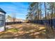 View of spacious fenced backyard and the rear exterior of the white sided home with black trim at 6107 Waterton Dr, Lithonia, GA 30058