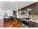 Modern kitchen featuring dark cabinets, stainless steel appliances, and tile backsplash at 6107 Waterton Dr, Lithonia, GA 30058