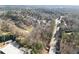 Overhead view of real estate and golf course bordering mature trees and a road at 10 Club Ct, Alpharetta, GA 30005