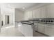 Wet bar and countertop featuring white cabinets, decorative black and white backsplash, and tile flooring at 10 Club Ct, Alpharetta, GA 30005