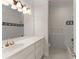 Bathroom featuring white vanity with gold fixtures, and tiled shower with decorative tile accents at 10 Club Ct, Alpharetta, GA 30005