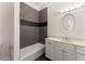 Bathroom with modern vanity, sleek lighting, dark accent tiles, and well-maintained bathtub at 10 Club Ct, Alpharetta, GA 30005