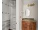 Bathroom featuring granite countertop, custom cabinet, oval mirror and storage shelves at 10 Club Ct, Alpharetta, GA 30005