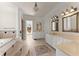 Luxurious bathroom with dual vanities, tiled floor, soaking tub, and natural light at 10 Club Ct, Alpharetta, GA 30005