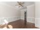 Bedroom featuring a ceiling fan, dark hardwood floors, and classic wainscoting at 10 Club Ct, Alpharetta, GA 30005