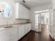 Butler's pantry with granite countertops, white cabinets and dark wood floors at 10 Club Ct, Alpharetta, GA 30005